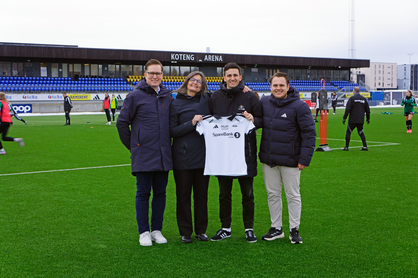 Personer på en fotballbane som viser frem en RBK drakt