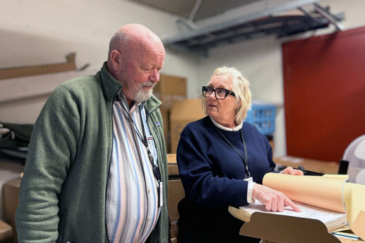Bjarne og Irene studerer gamle dokumenter fra arkivet. 
