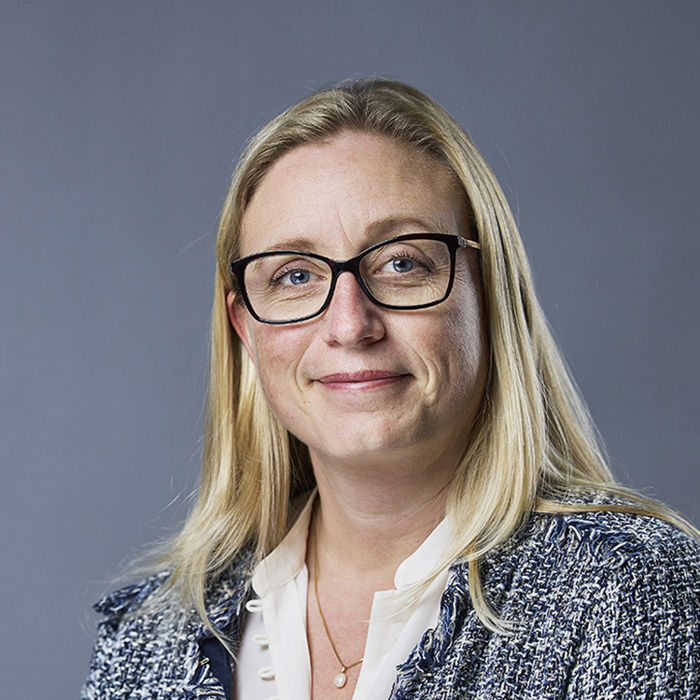 Blid dame med hvit bluse og blå jakke