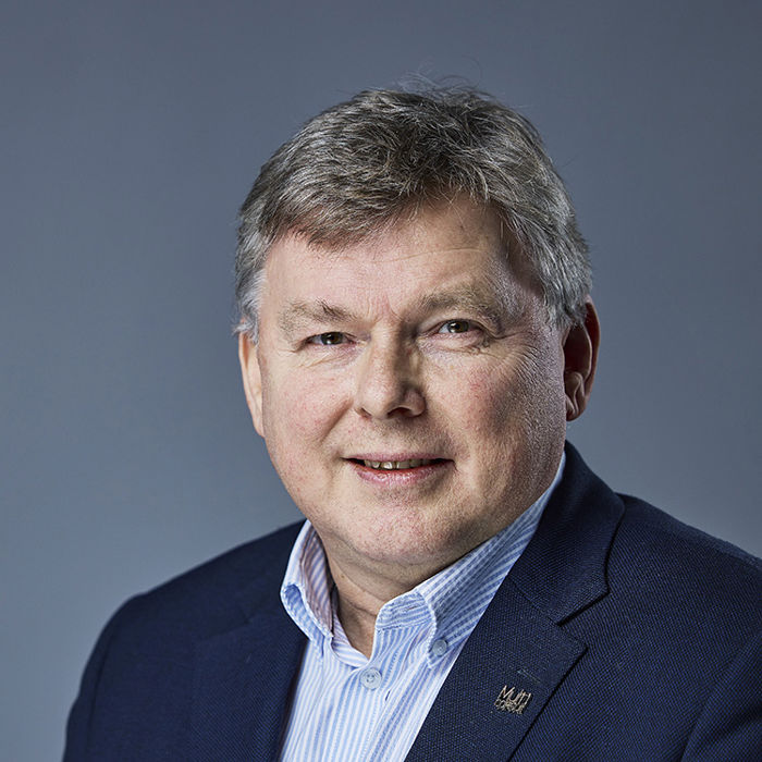 Blid mann med blå stripete skjorte og blå jakke